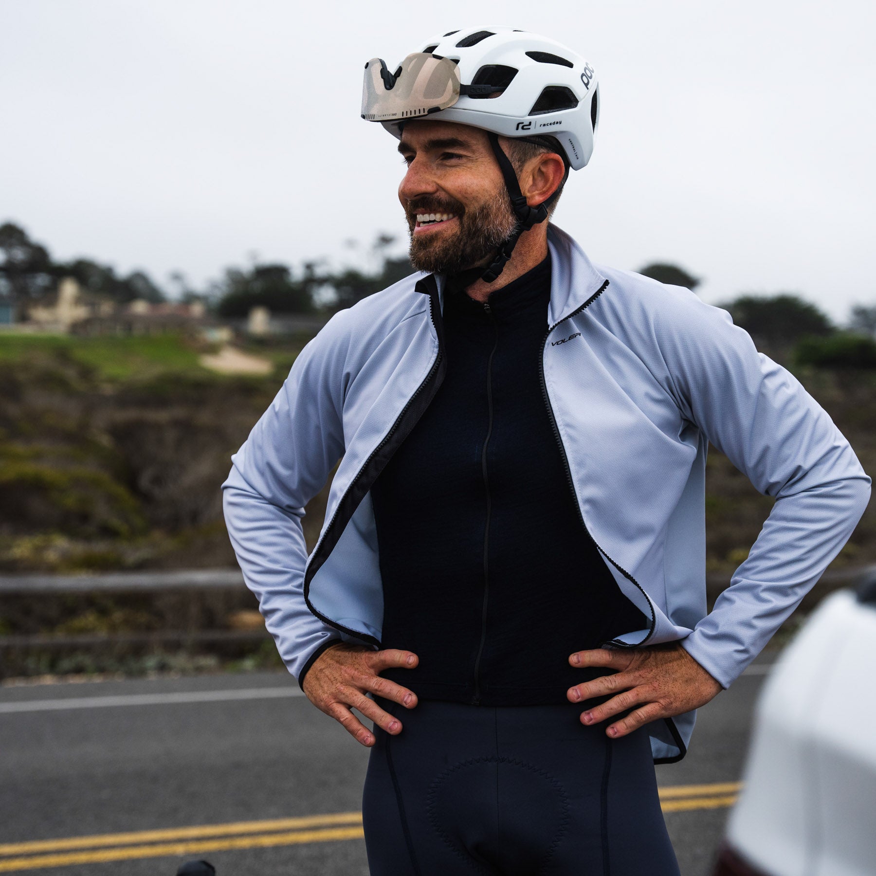 man wearing cycling apparel smiling unzipped jacket