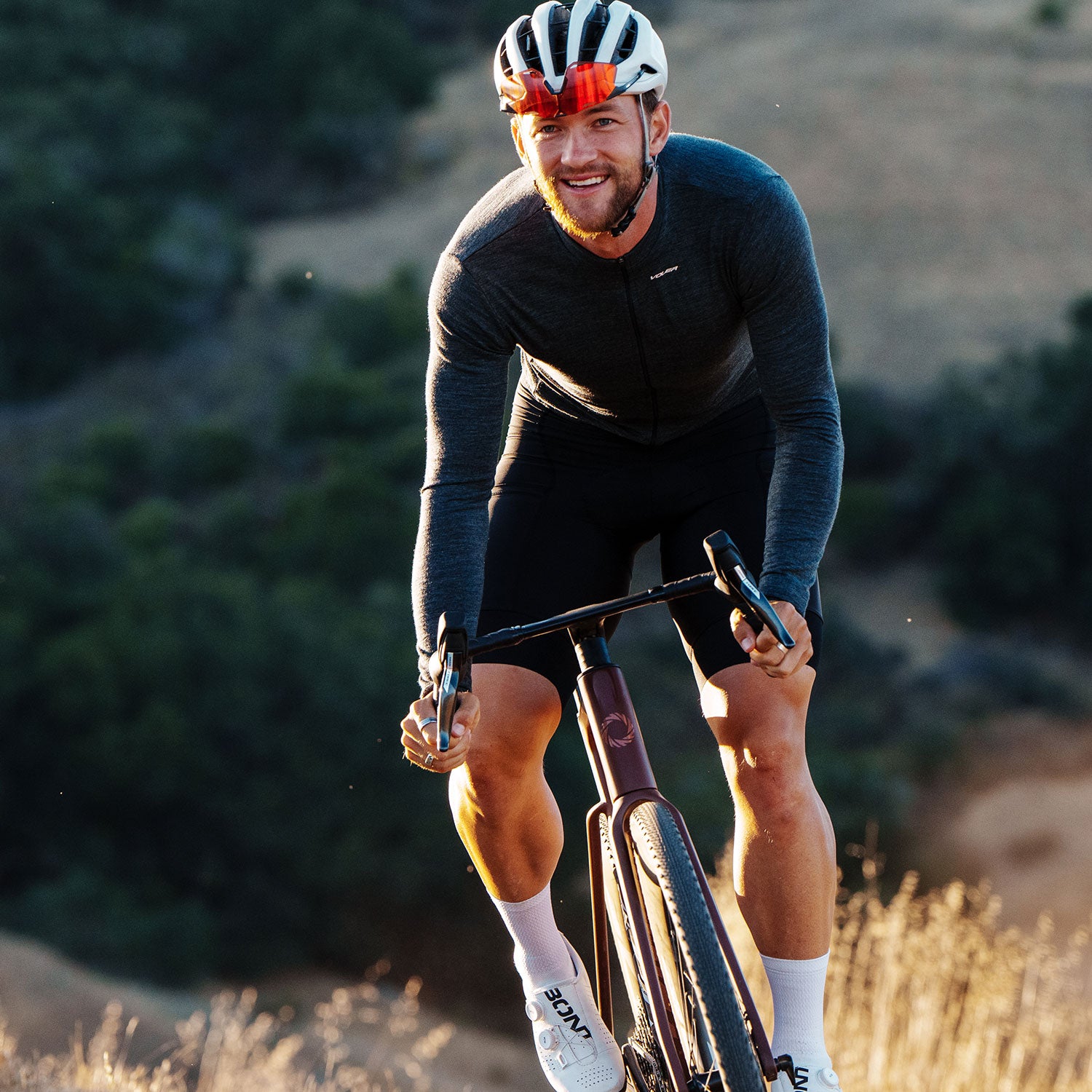 Man riding a bicycle on a trail with a helmet and sunglasses