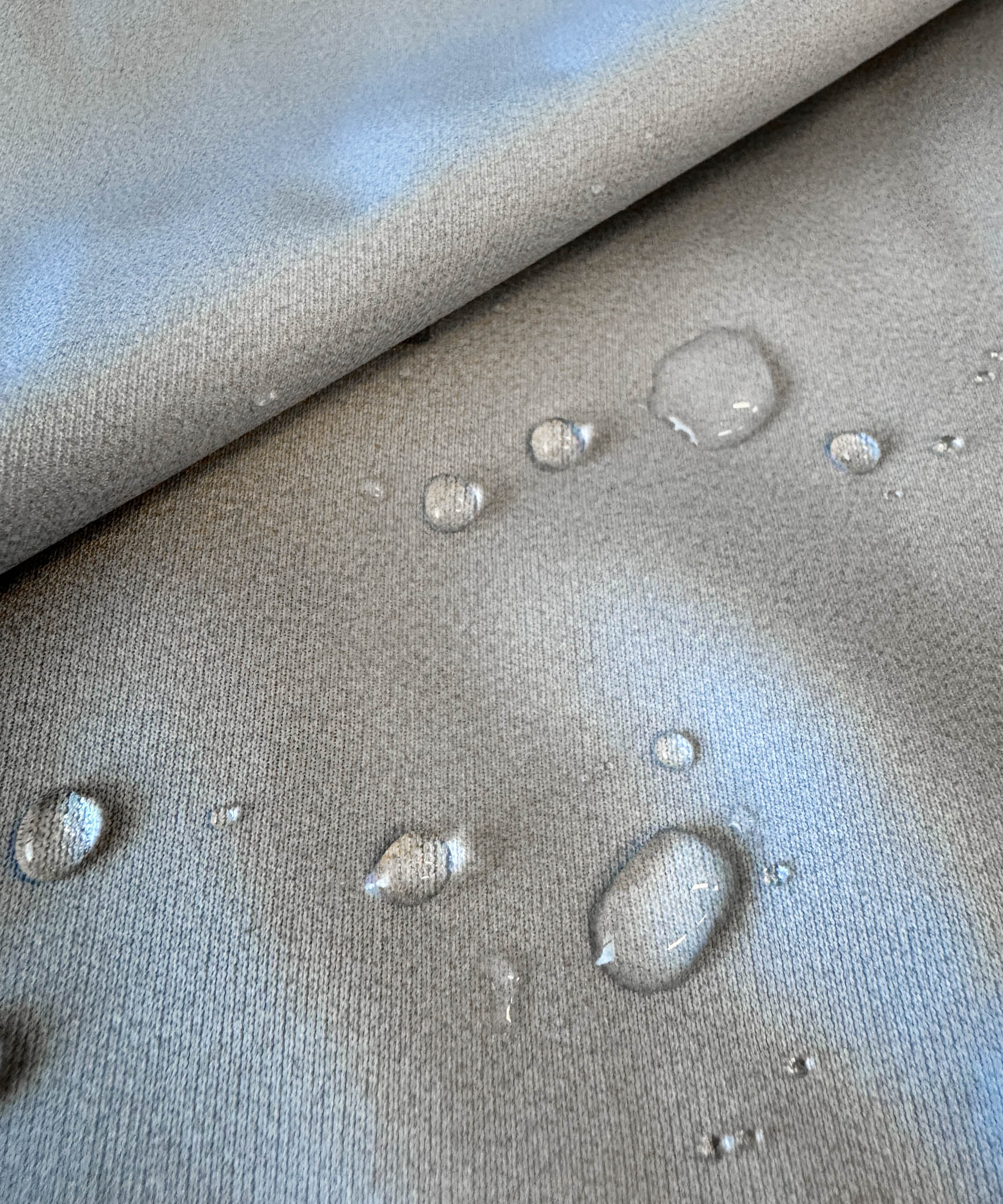 Water droplets on a textured gray surface