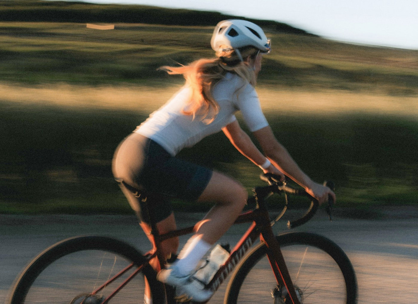 Woman riding a road bike at golden hour